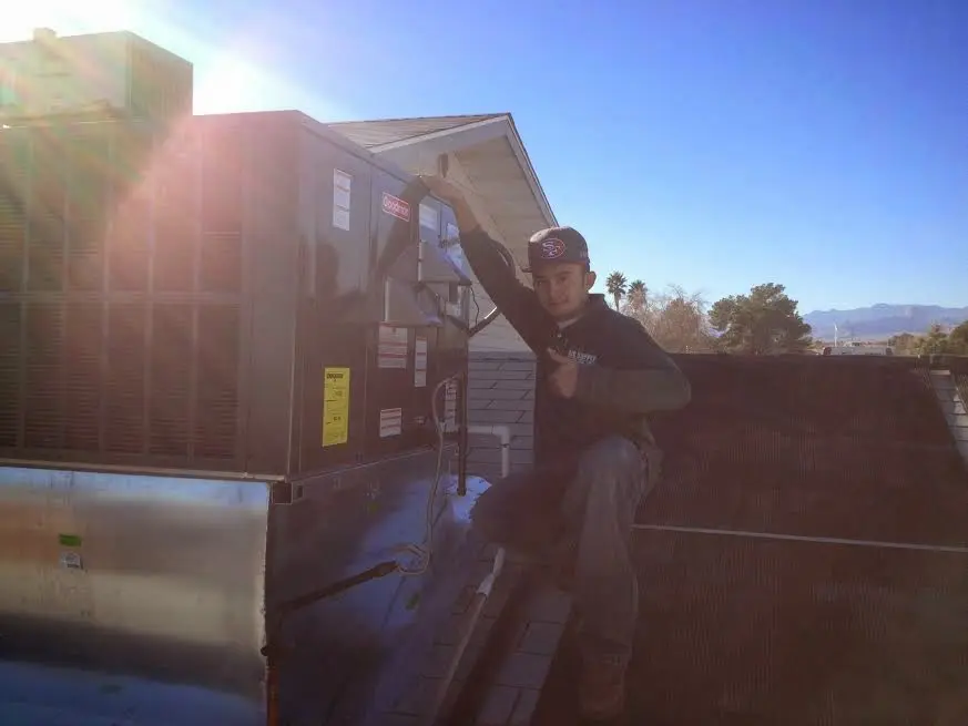HVAC technician performing AC Tune-Up on a rooftop unit in Carmichael